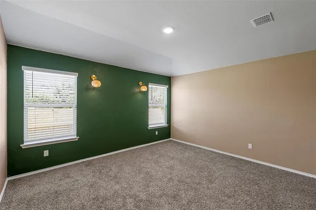 an empty room with closet and windows