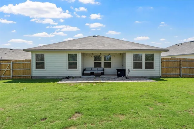a view of a house with a backyard and a patio