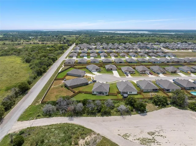 an aerial view of residential houses with outdoor space and trees