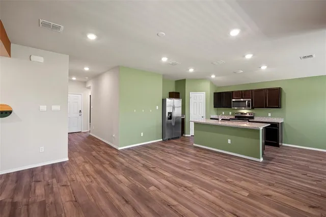 a large kitchen with stainless steel appliances kitchen island a refrigerator and a sink