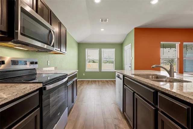 a kitchen with stainless steel appliances granite countertop a stove and a sink