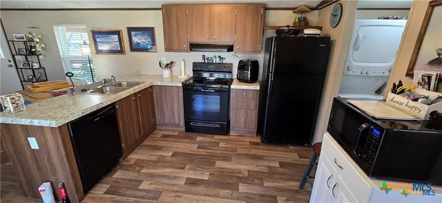 a kitchen with granite countertop a refrigerator stove and sink