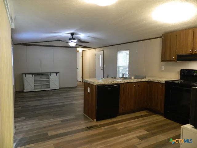 a kitchen with granite countertop cabinets and wooden floor