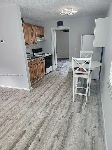 a view of a kitchen with microwave and furniture