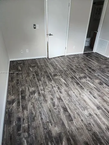 a view of a room with wooden floor