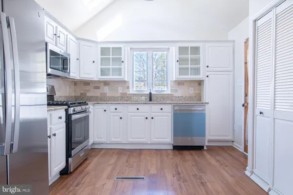a kitchen with stainless steel appliances granite countertop a stove a sink and a refrigerator