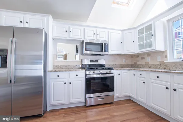 a kitchen with cabinets stainless steel appliances and a counter space