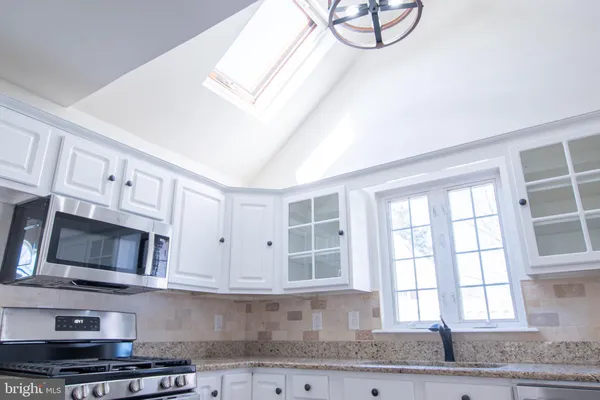 a kitchen with stainless steel appliances granite countertop a stove a microwave and a sink