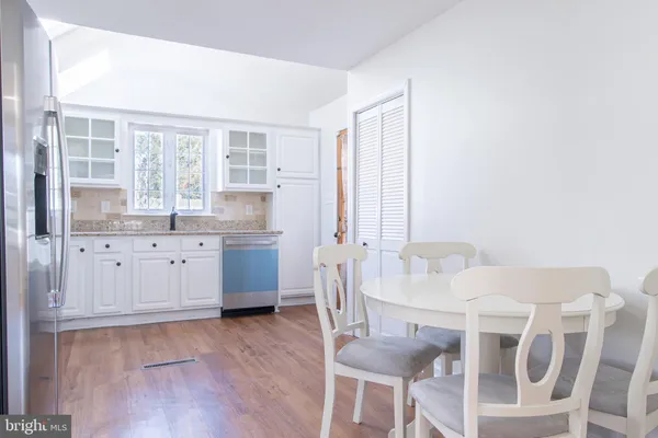a kitchen with granite countertop a sink cabinets and wooden floor
