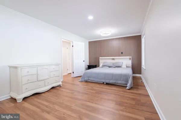 a spacious bedroom with a bed and cabinet