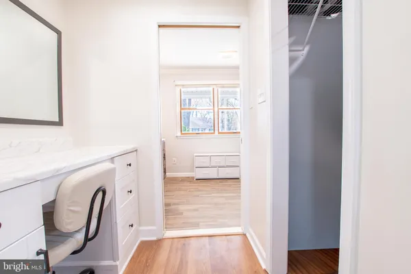 a view of a hallway with a chair and wooden floor