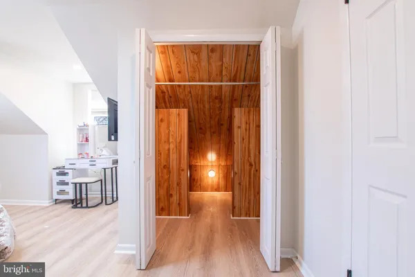 a view of a hallway to a livingroom with furniture and wooden floor