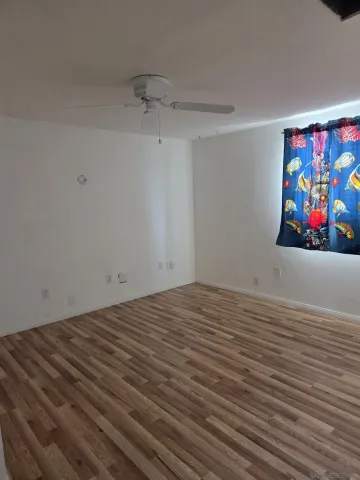 a view of a room with wooden floor and painting on the wall