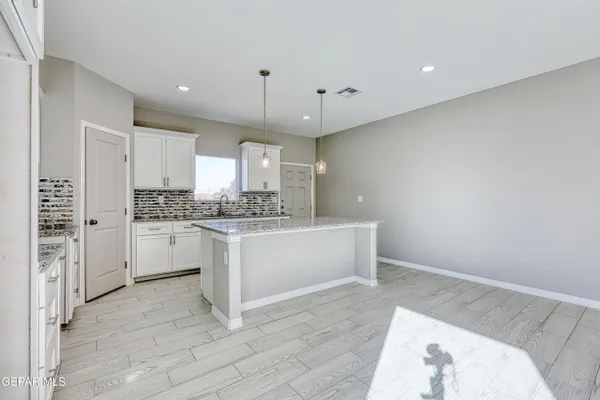 a kitchen with stainless steel appliances a stove a sink cabinets and a refrigerator