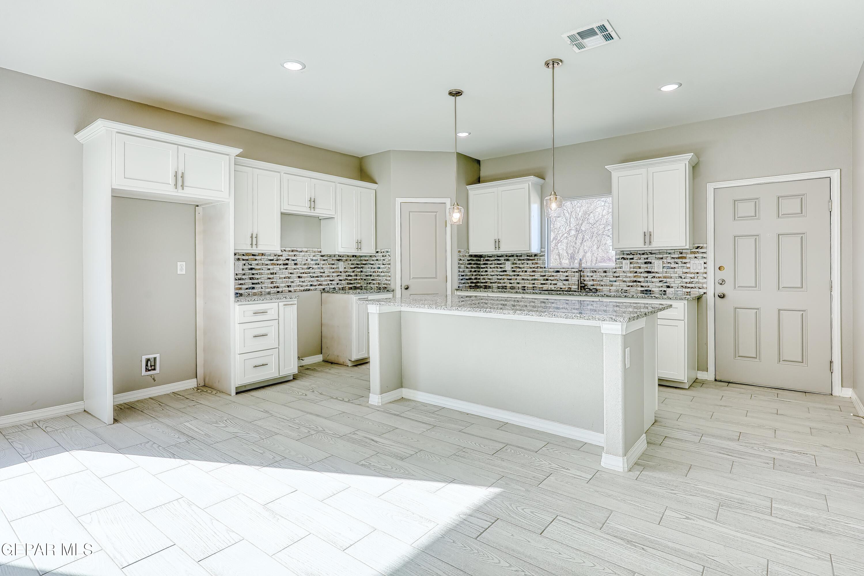 11607 Valle Bonito Road Socorro, TX 79927 - Photo 12 of 29 a kitchen with stainless steel appliances a stove a sink cabinets and a refrigerator