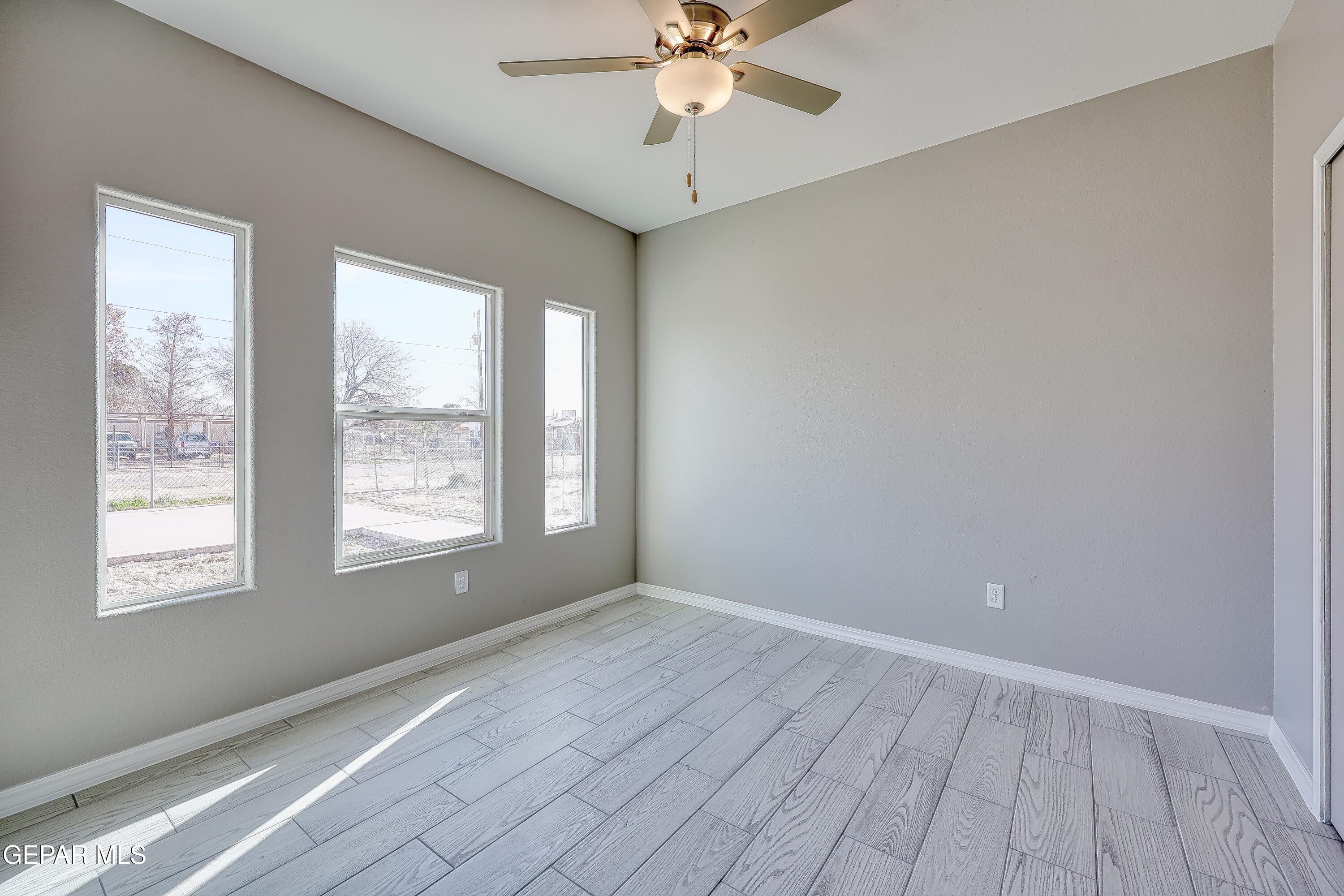 11607 Valle Bonito Road Socorro, TX 79927 - Photo 16 of 29 a view of an empty room with wooden floor and a window