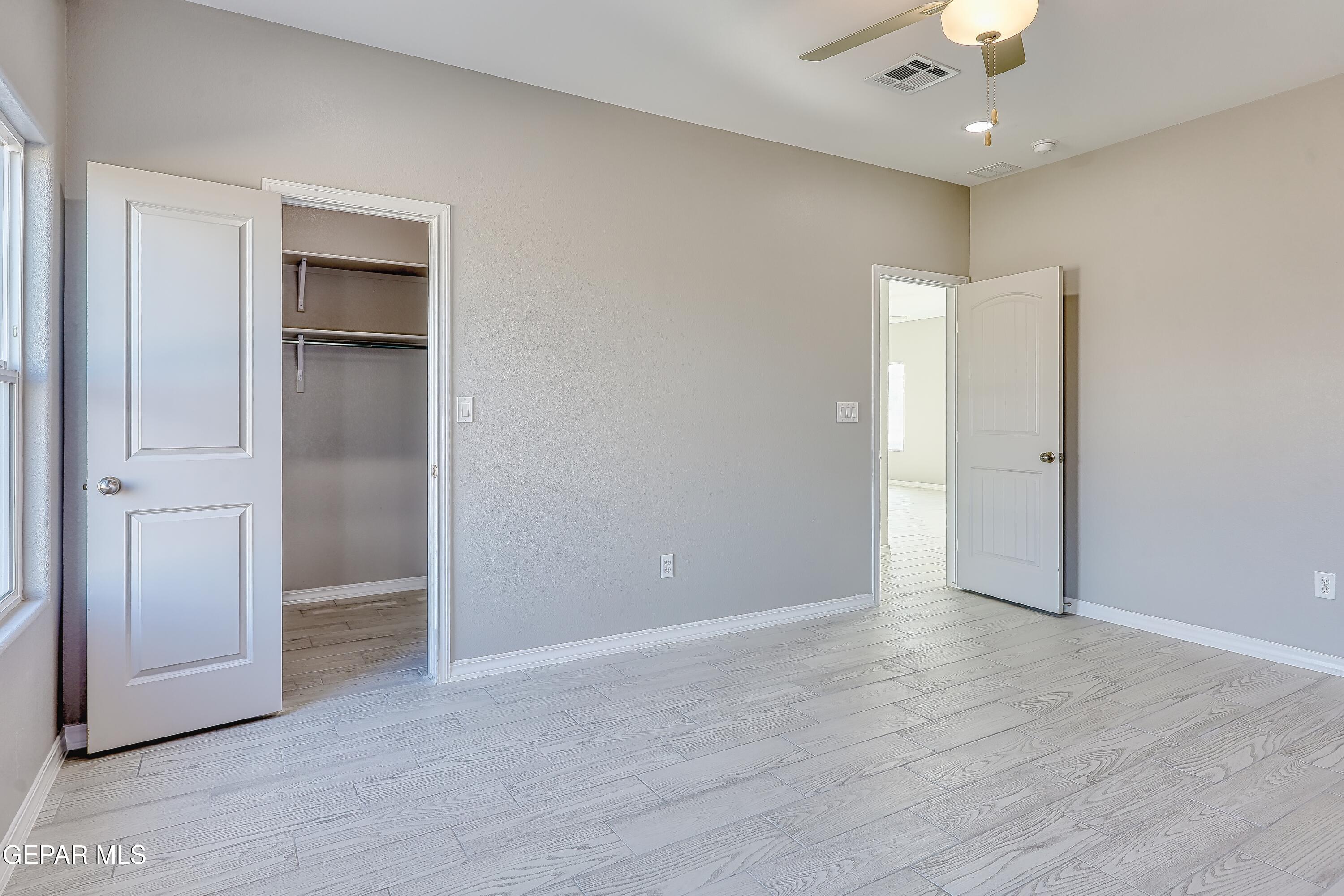11607 Valle Bonito Road Socorro, TX 79927 - Photo 24 of 29 an empty room with wooden floor and a ceiling fan