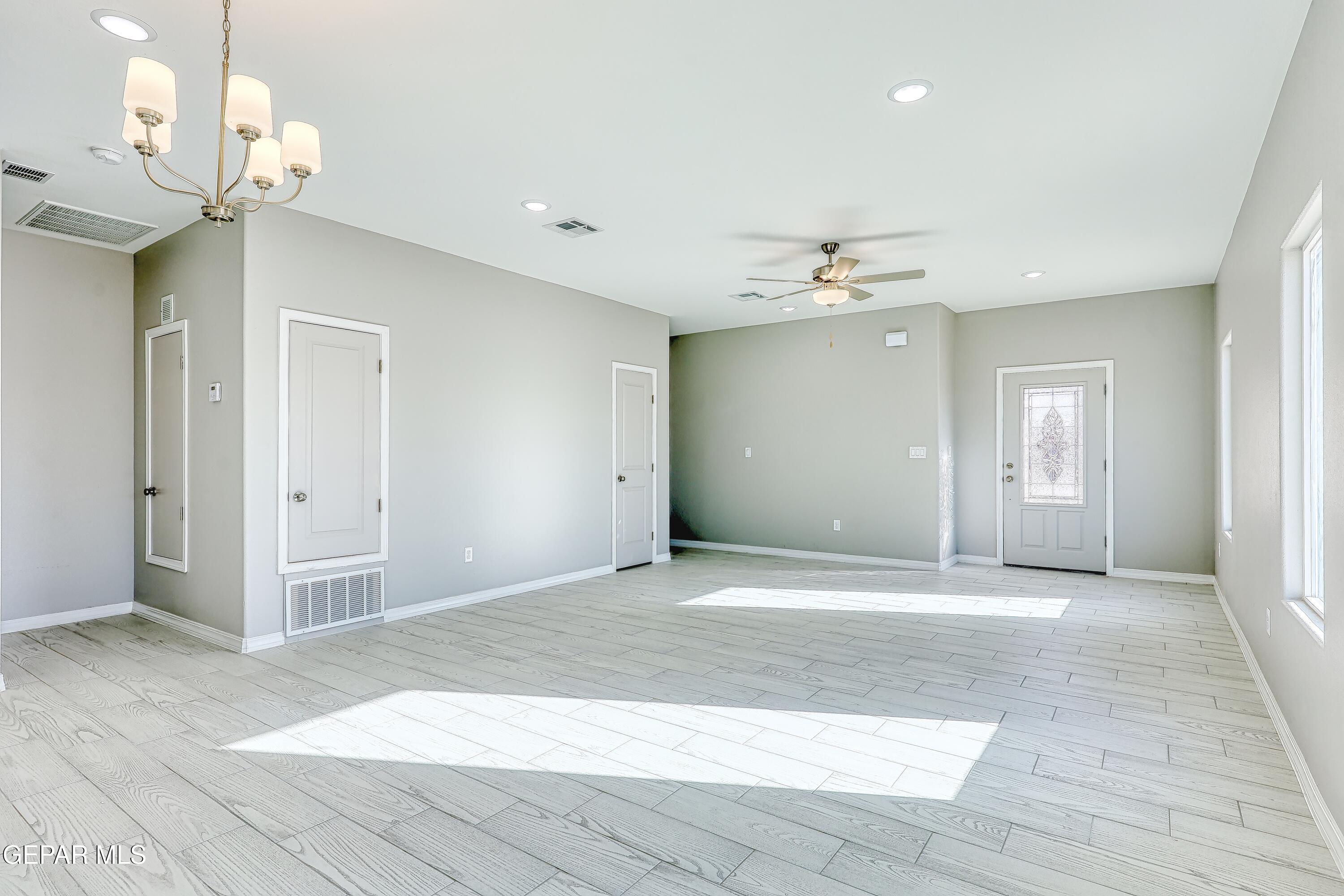 11607 Valle Bonito Road Socorro, TX 79927 - Photo 4 of 29 a view of a livingroom with a chandelier fan and kitchen view