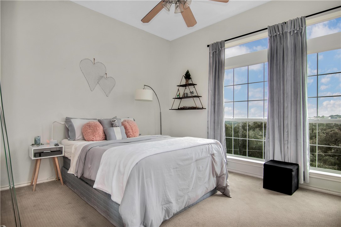 2918 Ranch Road 620 North, Unit W222 Austin, TX 78734 - Photo 22 of 30 a bedroom with a bed and a chandelier