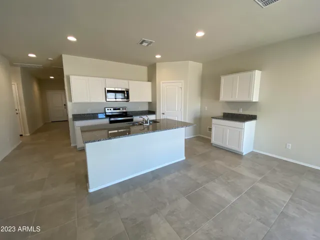 a kitchen with granite countertop a stove top oven and cabinets