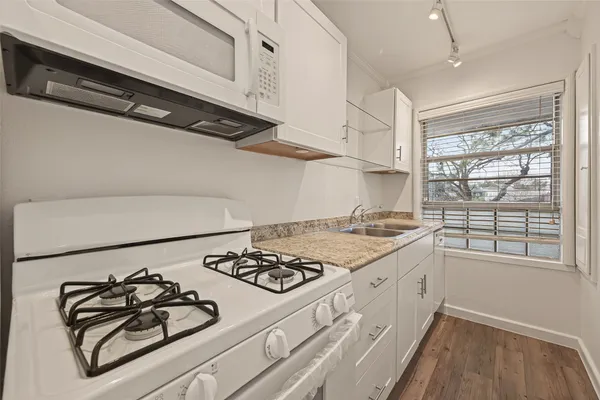 a kitchen with sink a stove and cabinets