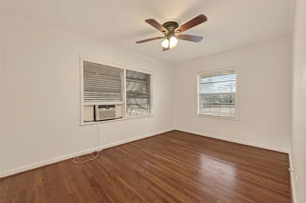 a view of a big room with wooden floor and windows