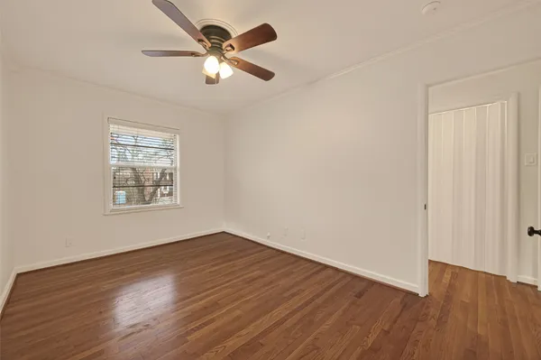 a view of a big room with wooden floor and windows