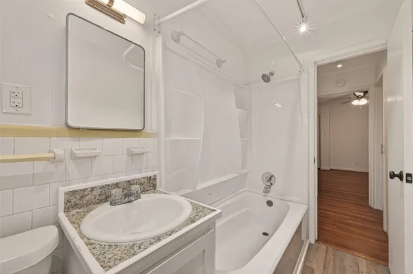 a bathroom with a tub a sink and a mirror