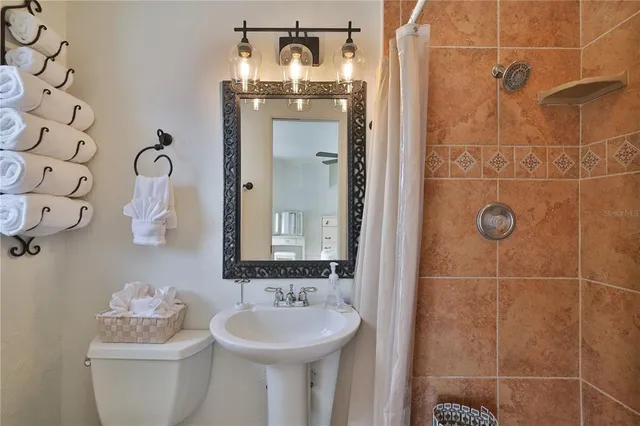 a bathroom with a sink and mirror with toilet