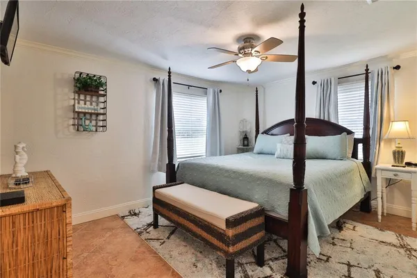 a bedroom with a bed a chandelier and a dresser