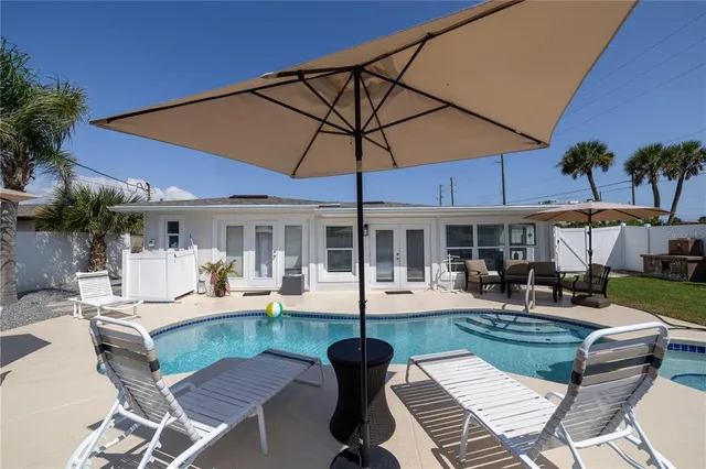 a view of a patio with a table and chairs under an umbrella