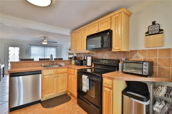 a kitchen with stainless steel appliances granite countertop a stove a sink dishwasher and a microwave oven with cabinets