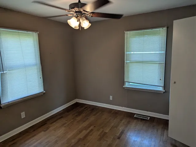 a view of wooden floor chandelier and window in a room