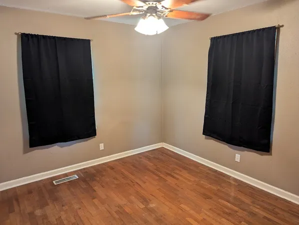 a view of an empty room with wooden floor