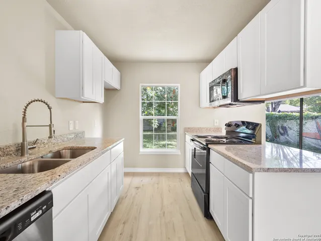 a kitchen with stainless steel appliances granite countertop a sink stove and cabinets