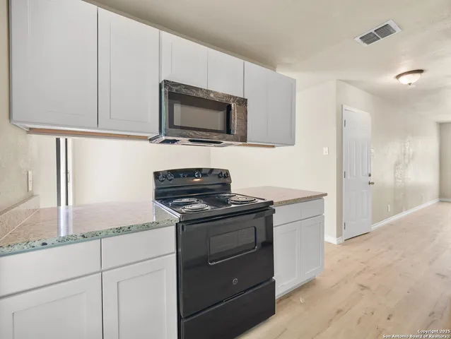 a kitchen with cabinets stainless steel appliances and a counter space