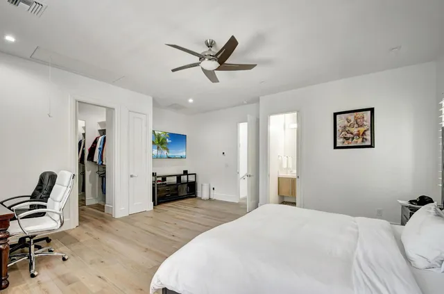 a bedroom with a bed and a computer on a table