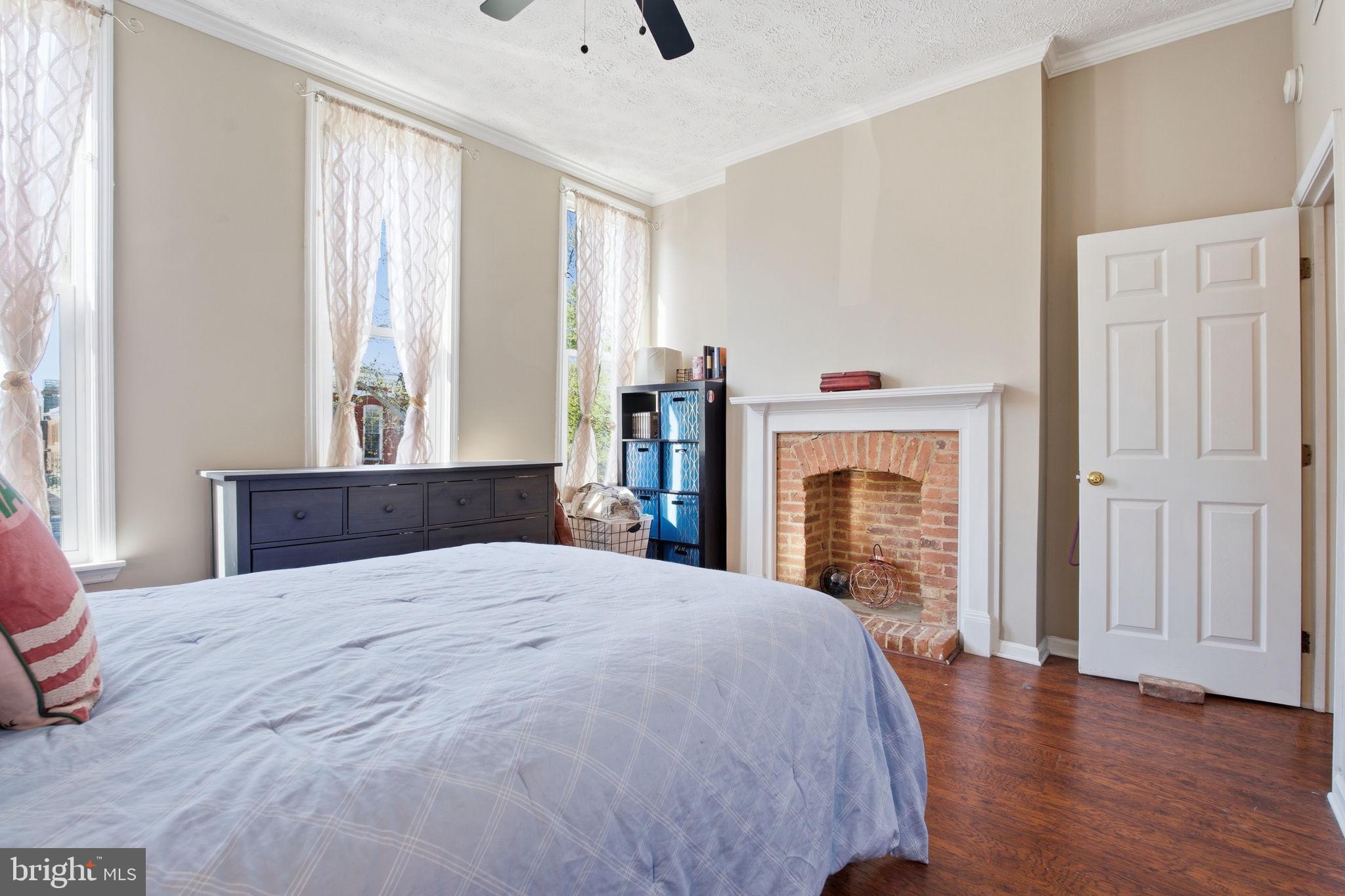 116 West Clement Street Baltimore, MD 21230 - Photo 25 of 32 a bedroom with a large bed and a fireplace