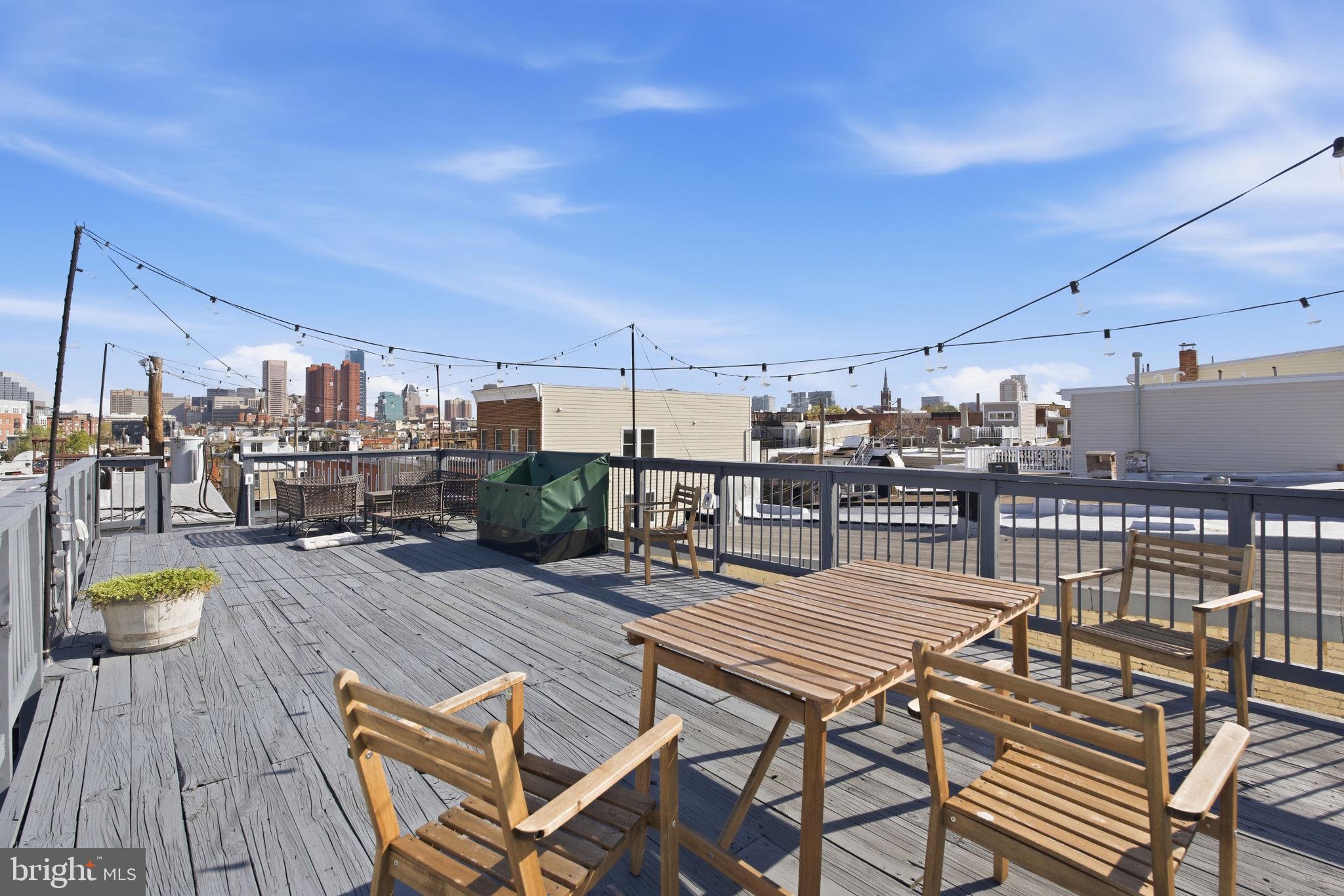 116 West Clement Street Baltimore, MD 21230 - Photo 30 of 32 a view of a roof deck with dining table and chairs