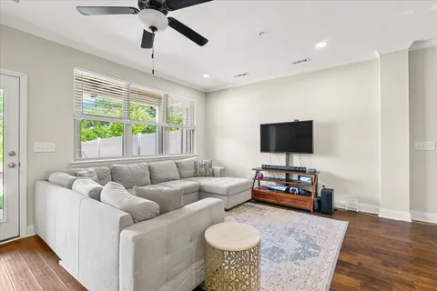 a living room with furniture flat screen tv and a large window