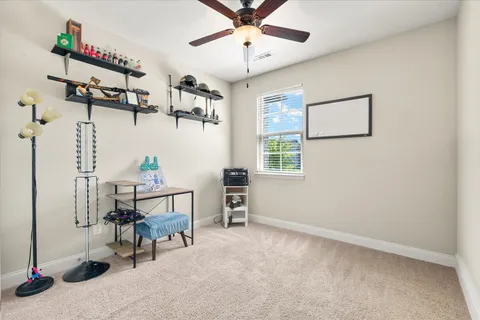 an empty room with fan and windows