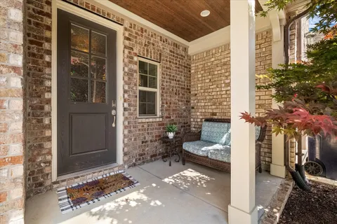 a view of a porch with a bench and potted plants