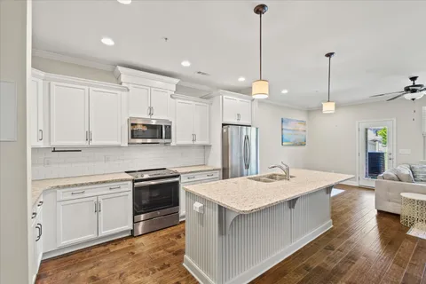 a kitchen with stainless steel appliances kitchen island granite countertop a stove sink and refrigerator