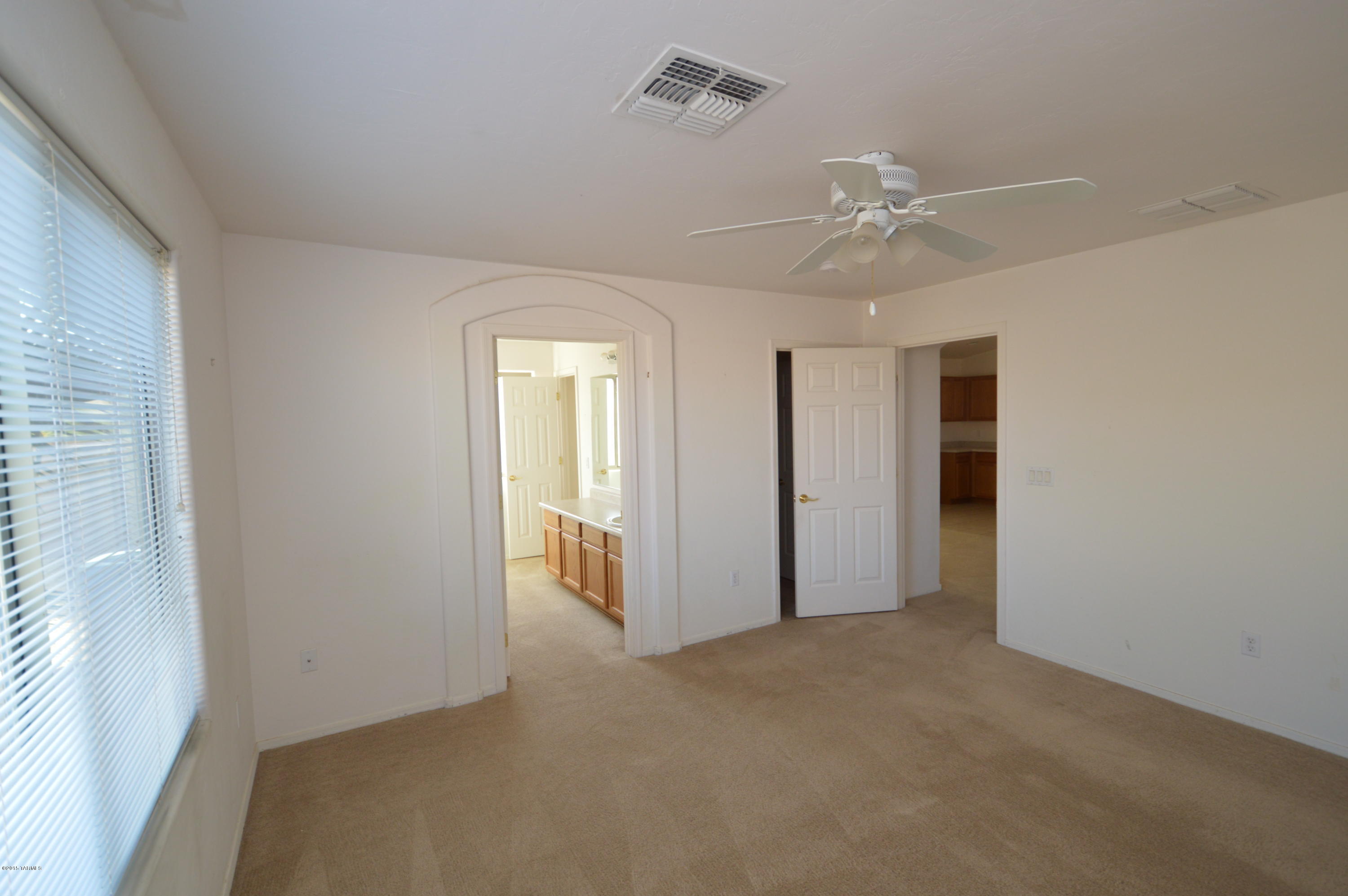 8396 West Benidorm Loop Tucson, AZ 85757 - Photo 6 of 13 an empty room with chandelier fan and windows