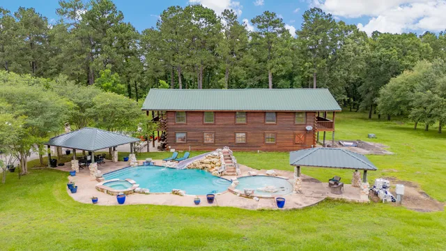 an aerial view of a swimming pool with table and chairs under an umbrella