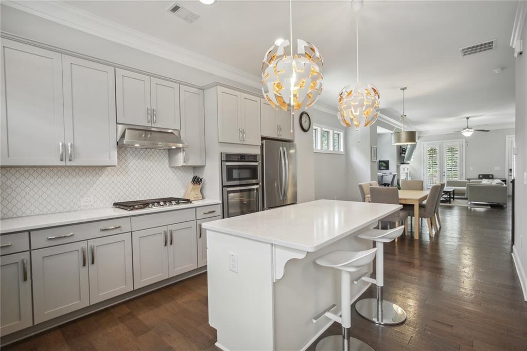 a kitchen with stainless steel appliances a table chairs and a chandelier