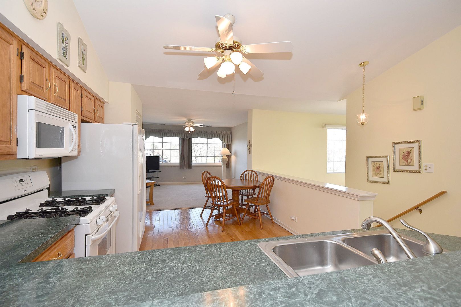 8279 Ripple Ridge, Unit 8279 Darien, IL 60561 - Photo 22 of 28 a kitchen with stainless steel appliances granite countertop a sink dishwasher a stove and a dining table with wooden floor