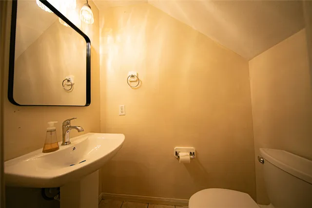 a bathroom with a sink mirror and toilet