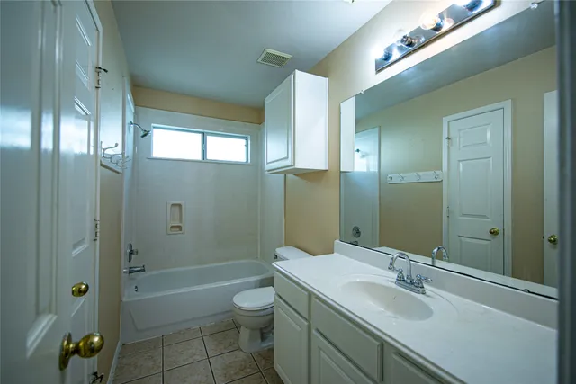 a bathroom with a granite countertop sink a toilet and shower