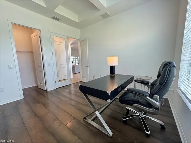 a view of a workspace with furniture and wooden floor